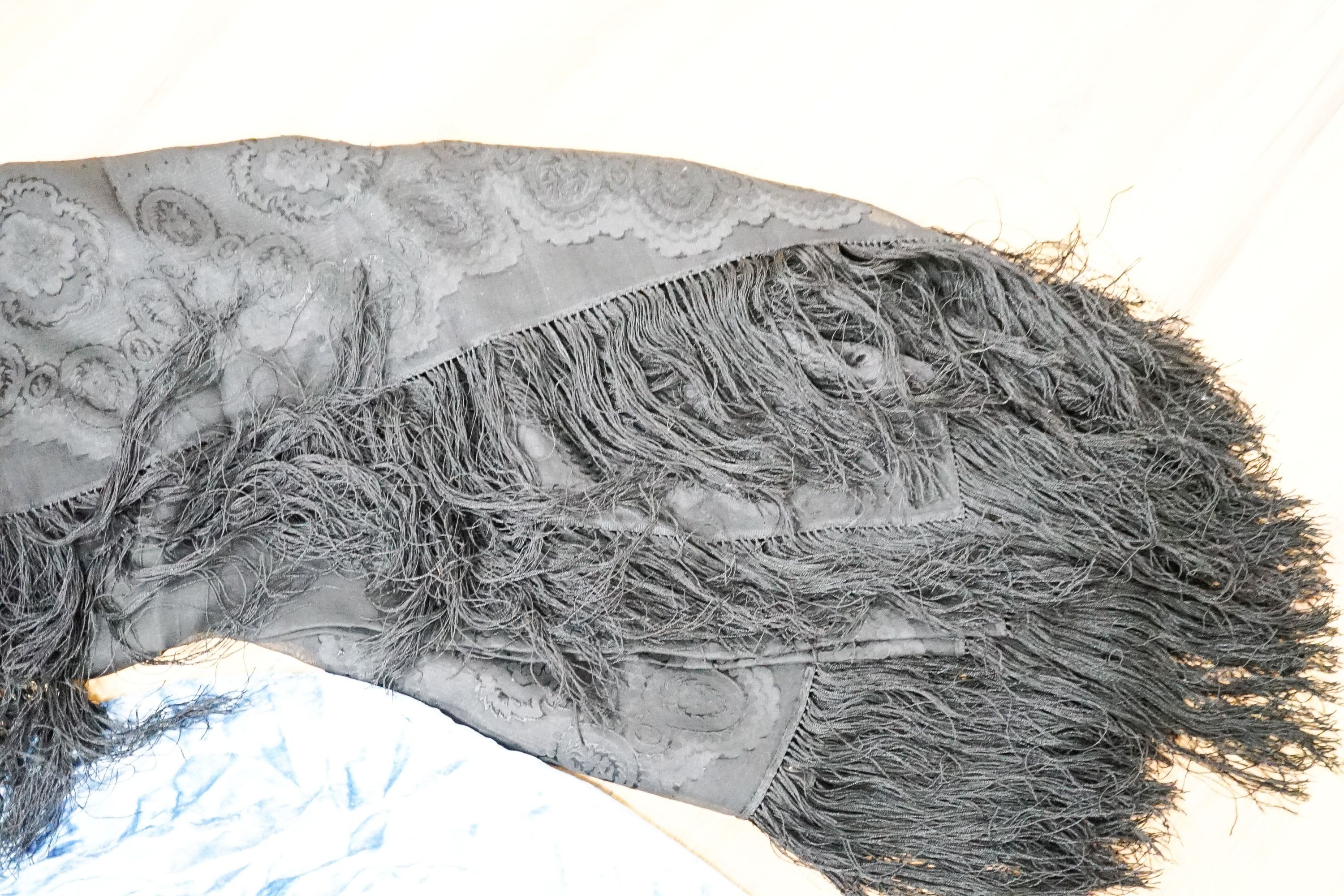 A Victorian black silk evening shawl, a 1920's blue silk velvet decorated with beading together with a beige satin evening dress